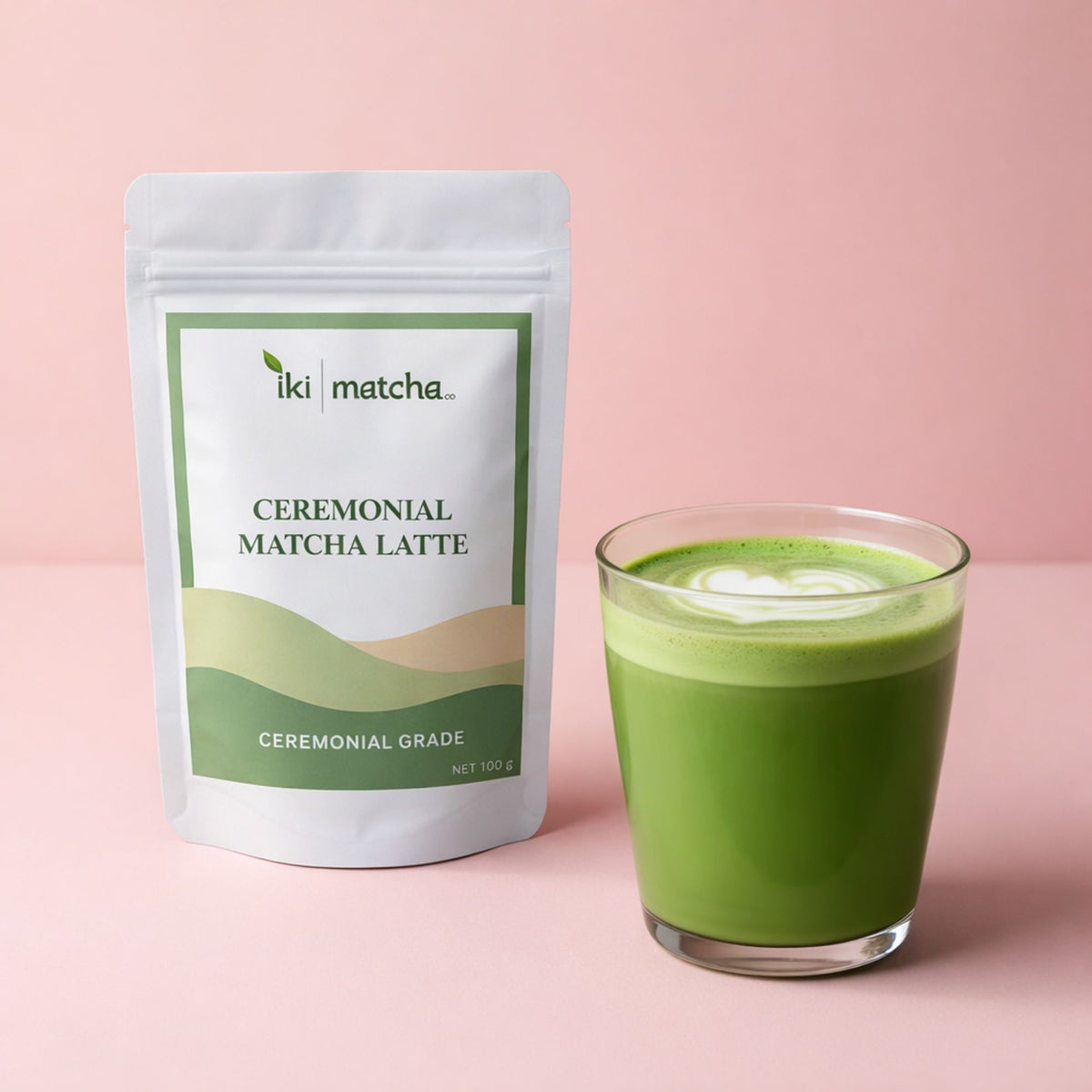 Iki Matcha ceremonial matcha latte packaging and a glass of green latte on a pink background