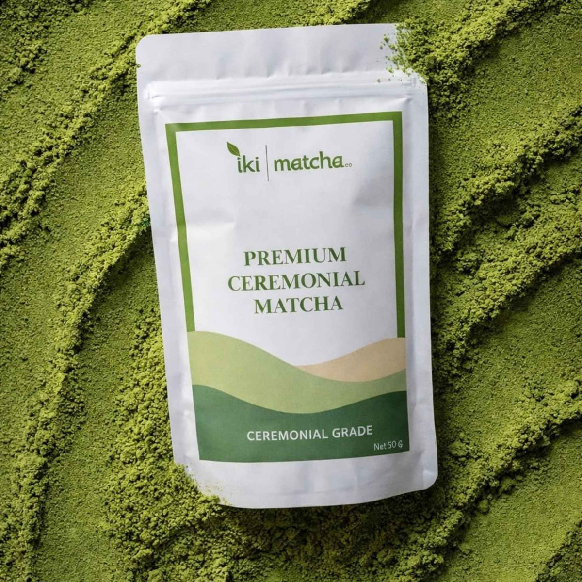 Package of iki matcha premium ceremonial matcha powder on a bed of green matcha powder.