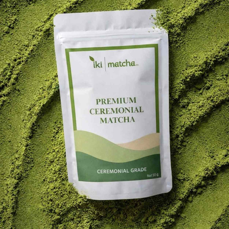 Package of iki matcha premium ceremonial matcha powder on a bed of green matcha powder.